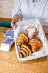 A tempting display of croissants in a wooden basket at the checkout.