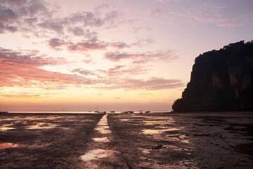 Fototapeta na wymiar The dramatic gritty sandy landscape of Hat Rai Leh East beach at low tide at sunrise, Railey Bay, Thailand