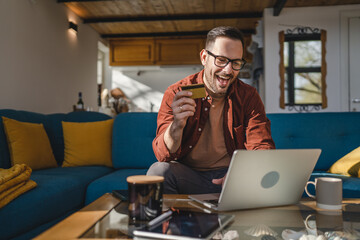 One man caucasian male online shopping use laptop and hold credit card