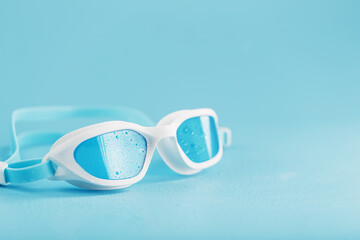 White swimming glasses with a blue lens