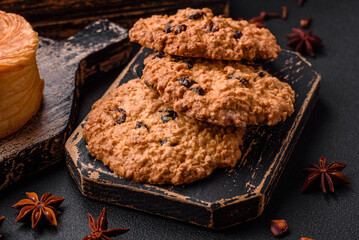 Delicious baked oatmeal raisin cookies on a dark concrete background