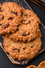 Delicious baked oatmeal raisin cookies on a dark concrete background