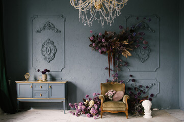 Vintage chest of drawers decorated with flowers in the interior with stucco on the wall, luxury...