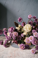 A composition of stabilized purple and gold flowers adorn the wall of the interior of the house