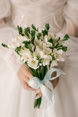 Wedding bouquet of white eustomas in the hands of the bride