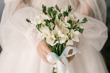 Wedding bouquet of white eustomas in the hands of the bride