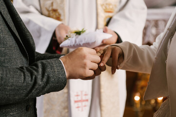 The bride and groom exchange rings in the church, the sacrament of the wedding