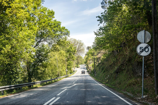 Image of a section of national road 103, N103, between the municipalities of Viana do Castelo and Bragança, surrounded by beautiful and verdant spring vegetation. Vertical signage.