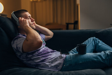 Side view of a Caucasian man putting on his headset and relaxing in the evening.