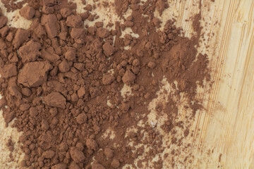 Cocoa powder on wooden background, top view, close up