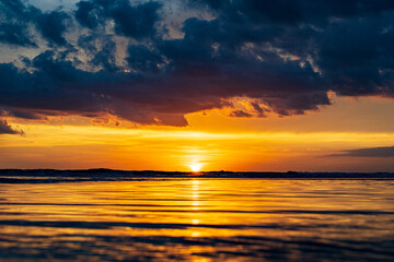 the sun sets below the water in a tropical scene 