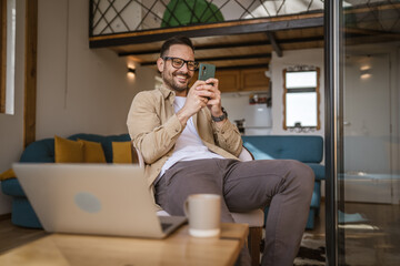 caucasian man sit at home play video games on smartphone mobile phone