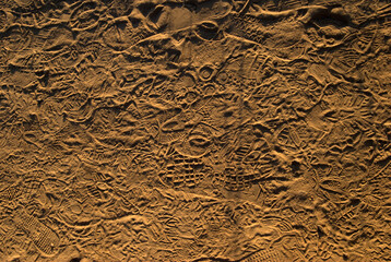 multiple overlapping footprints in dirt in late afternoon