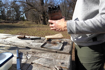 Preparations before small camp fire. Only hands visible. One spring day at the park. Sweden, April 2023.
