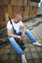 Fototapeta premium Rifleman sitting with a gun in hands