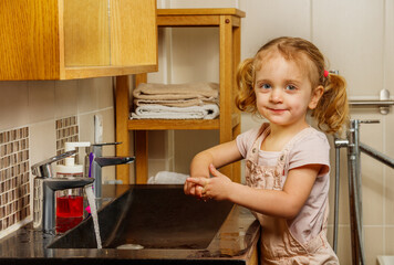 Beautiful girl wash hands in bathroom smile looking at camera