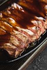 Appetizing steak cut into slices with sauce. Meat close-up.