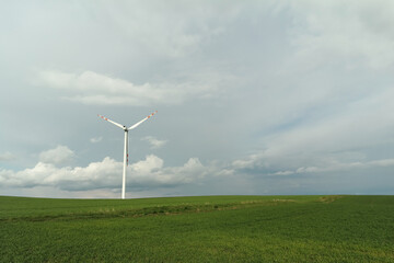 Wiatrak farmy wiatrowej na polach podczas nadchodzącej burzy. © Adam Sadlak