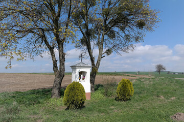 Kapilczka chrześcijańska przydrożna na wiosce, wiosenną porą.