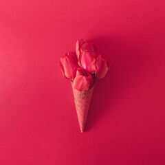 Ice cream cone with tulip flowers. Minimal spring concept. Flat lay. Monochromatic red.