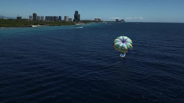 Flying past a parasail in the ocean