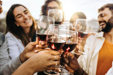 Fototapeta Young people toasting red wine glasses at farm house vineyard countryside - Happy friends enjoying happy hour at winery bar restaurant  obraz