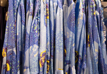 blue with yellow flowers summer blouses on a hanger in the store, bright clothes