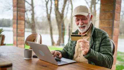 Man senior caucasian male shopping online sit with laptop computer