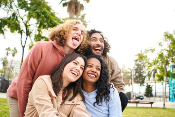 Fototapeta premium Happy friends from diverse cultures and races taking photo making funny faces - Youth, millennial generation and friendship concept. High quality photo