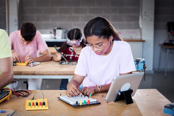 Young Latin girl student at technical high school are in classroom practicing hardware parts on circuit boards. Superior engineering concept development and innovation. People in technology class.