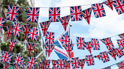Union Jack flags hanging at the street ready to national holiday celebration - obrazy, fototapety, plakaty
