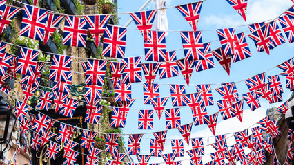 Union Jack flags hanging at the street ready to national holiday celebration - obrazy, fototapety, plakaty