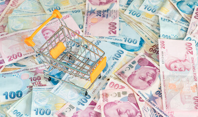 Cost of living concept. Empty cart on a stack of Turkish liras. Inflation rising in Turkey. Economic crisis. Rising costs in daily life
