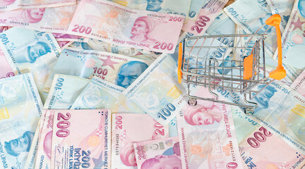 Cost of living concept. Empty cart on a stack of Turkish liras. Inflation rising in Turkey. Economic crisis. Rising costs in daily life