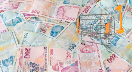 Cost of living concept. Empty cart on a stack of Turkish liras. Inflation rising in Turkey. Economic crisis. Rising costs in daily life