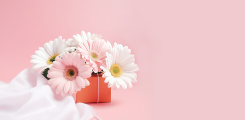 Cute bouquet of different flowers and festive box, pink background. Festive composition for Nurse's Day, wedding