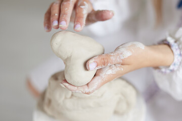 female hands holding a clay heart, pottery