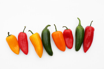 Different hot chili peppers on white background, flat lay