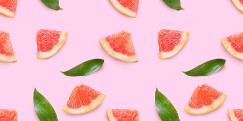 Fresh grapefruit slices on pink background