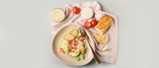 Naklejka na ściany i meble Plate with fresh Caesar salad on grey background