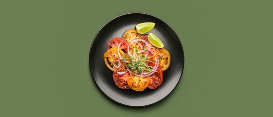 Plate with tasty tomato carpaccio on green background