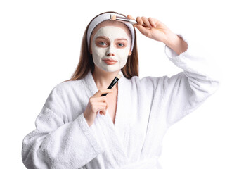 Young woman with applied turmeric mask and brushes on white background