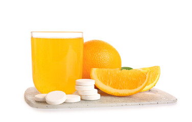 Board with glass of vitamin C effervescent tablet dissolved in water and orange isolated on white background