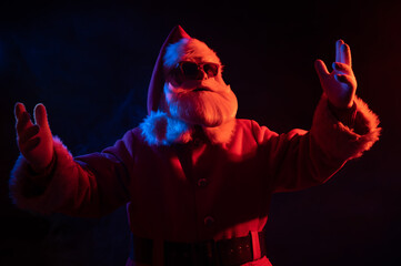 Portrait of Santa Claus in sunglasses in neon light.