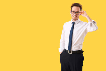 Young businessman on yellow background