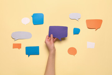Composition with woman holding blank speech bubble on beige background