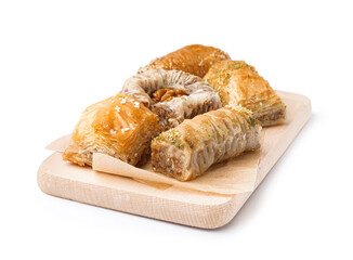 Wooden board with tasty baklava on white background