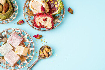 Plates with tasty Turkish Delight on blue background, closeup