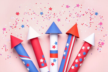 Obraz premium Firework rockets, confetti and serpentine for Independence Day on pink background