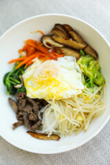 Vibrant and colorful bibimbap bowl filled with fresh and healthy vegetables, symbolizing a nutritious meal and the importance of a balanced diet for overall well-being